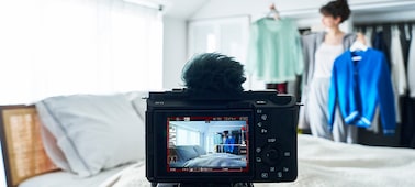 Hình ảnh chiếc máy ảnh đặt trên chân máy và ghi hình một phụ nữ